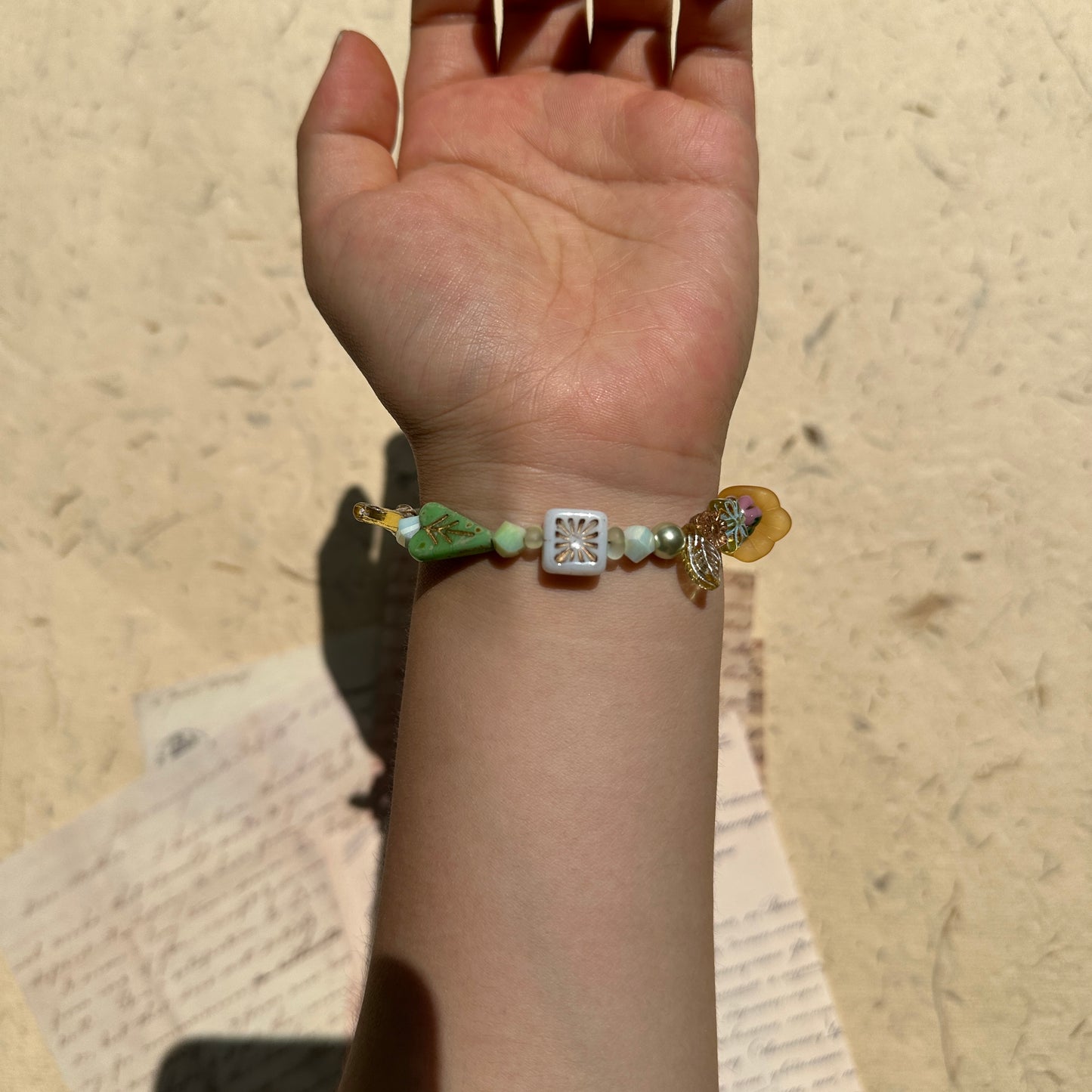 Artisan bracelet with yellow flower centerpiece and spring tones