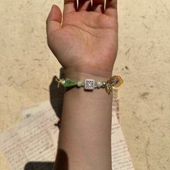 Artisan bracelet with yellow flower centerpiece and spring tones