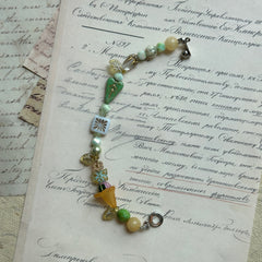 Handcrafted bracelet featuring floral charms and ivory beads