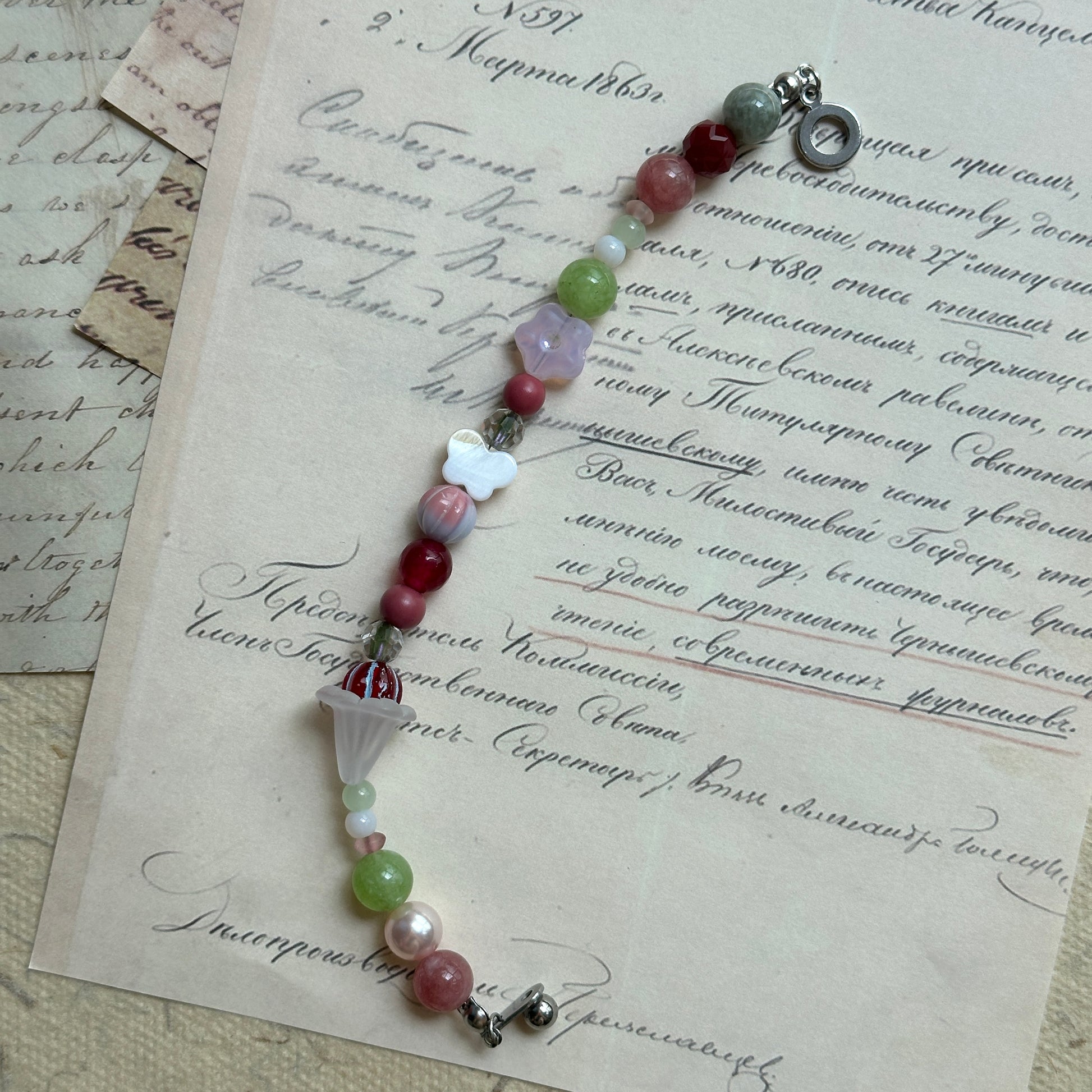 Handcrafted bracelet featuring blossoms, pearls, and pastel tones