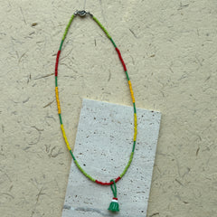 Close-up of green jelly-cake style pendant with red accent loop