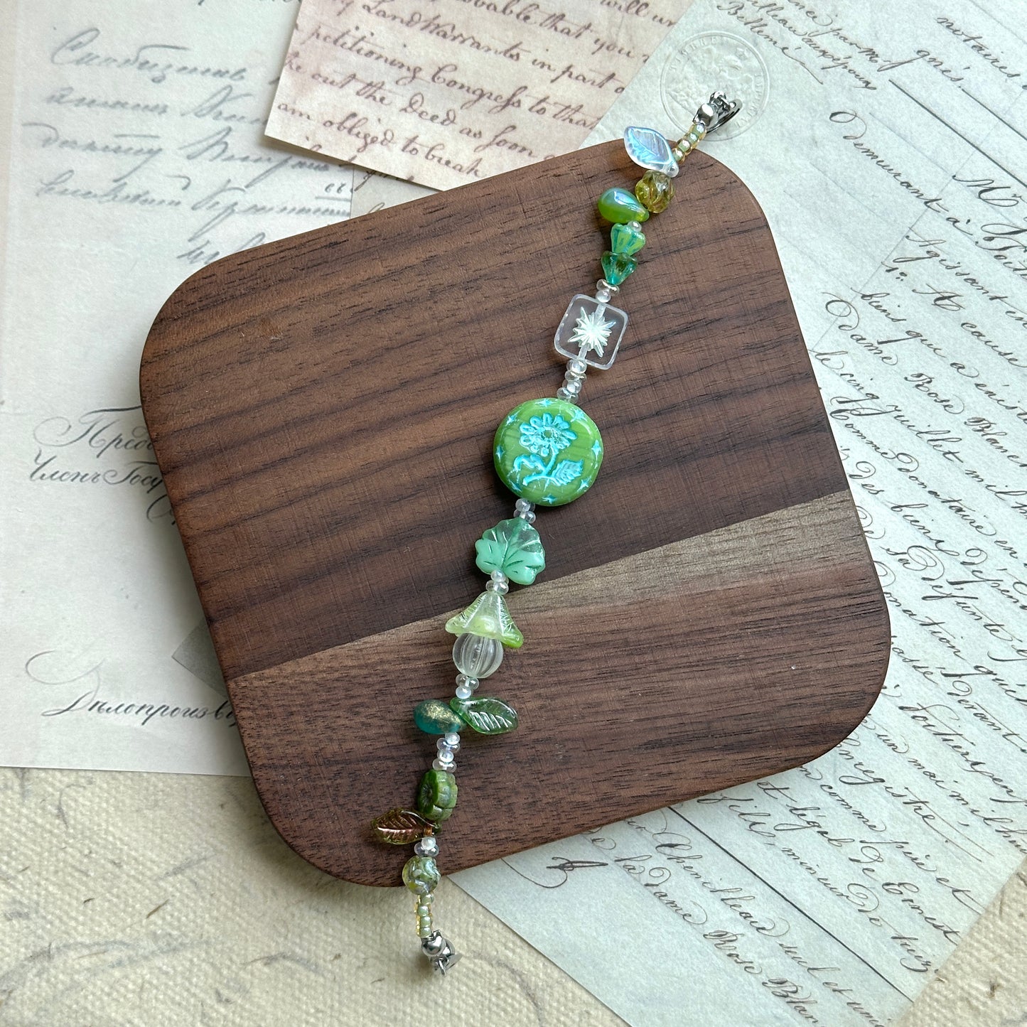 Handcrafted bracelet featuring blossoms, butterflies, and glass charms