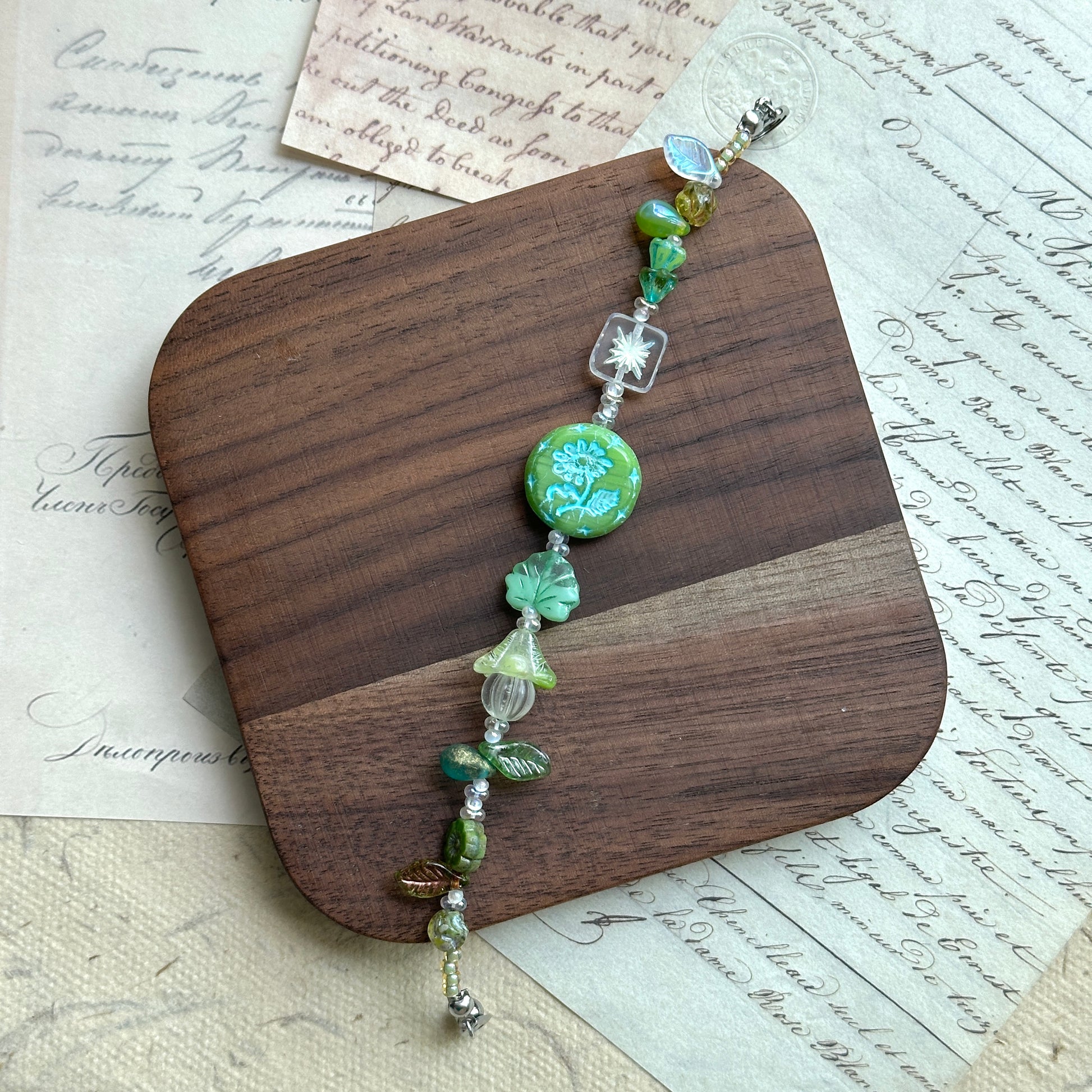 Handcrafted bracelet featuring blossoms, butterflies, and glass charms
