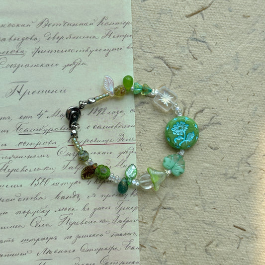 Secret Forest Blossom Bracelet with floral focal bead and green leaves