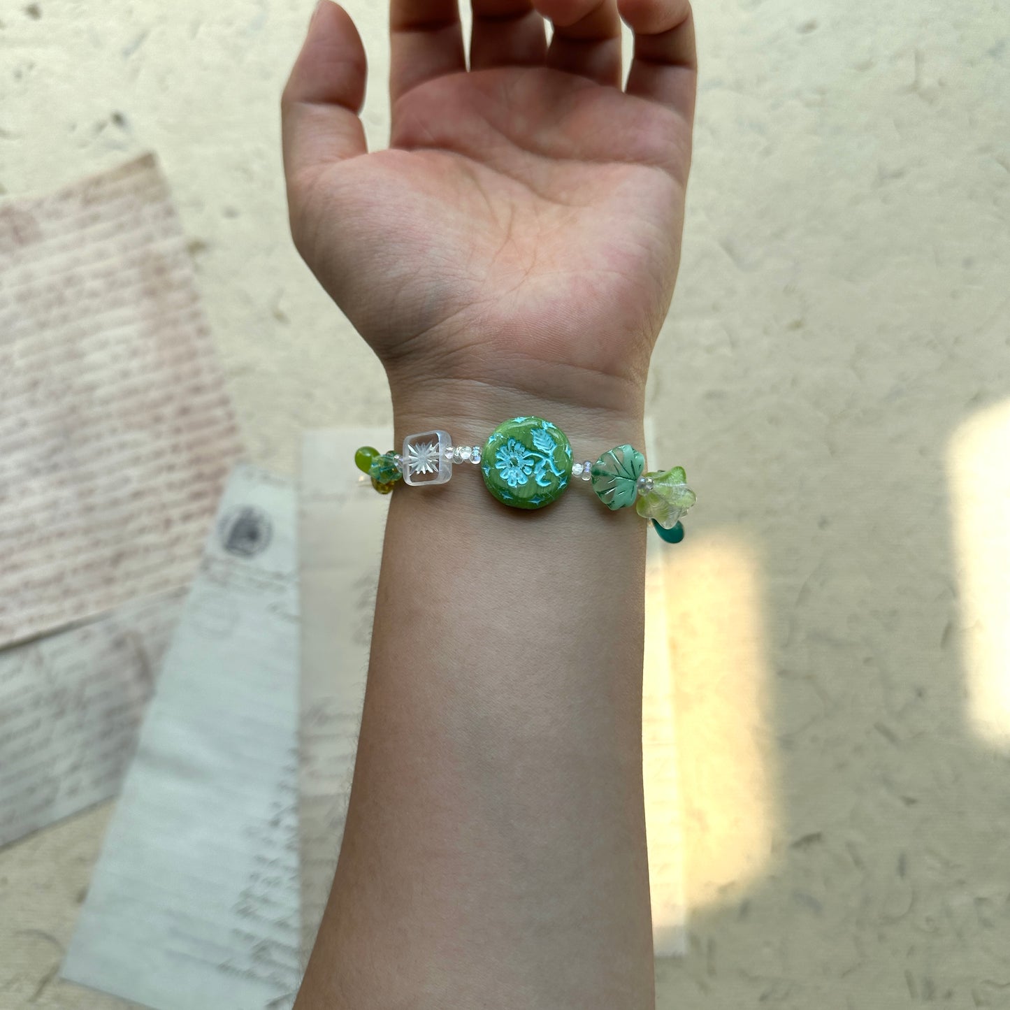 Artisan bracelet with central floral medallion and leafy accents