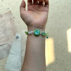 Artisan bracelet with central floral medallion and leafy accents