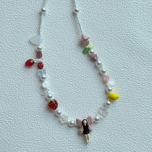 Fairy Garden Necklace with fairy pendant and fruit charms on display bust