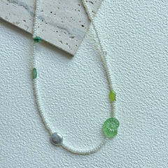 Lily Pond Necklace with green leaf bead and pearl-like accent on display bust