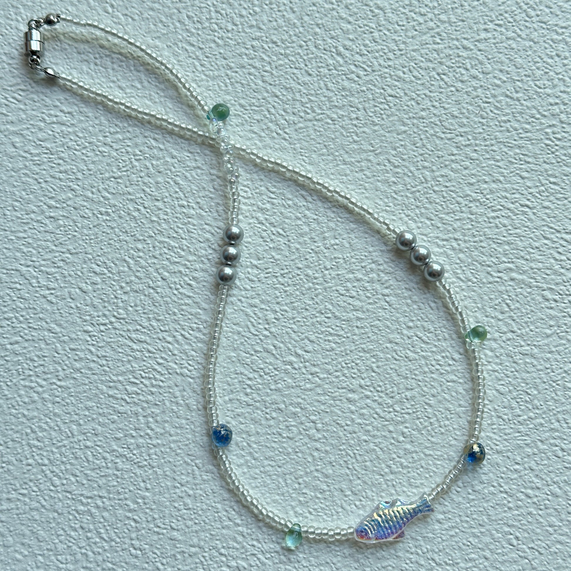 Close-up of shimmering fish bead with white seed beads