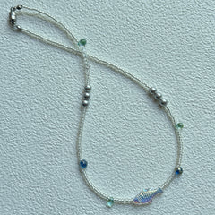 Close-up of shimmering fish bead with white seed beads