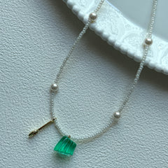 Aurora Green Necklace with green pendant and pearl accents on display bust
