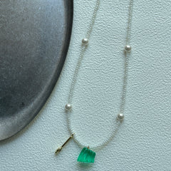 Close-up of transparent green glass pendant with seed beads