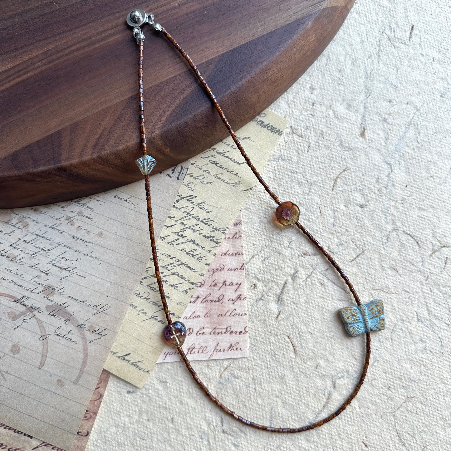 Brown seed bead strand with turquoise butterfly centerpiece