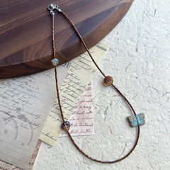 Brown seed bead strand with turquoise butterfly centerpiece