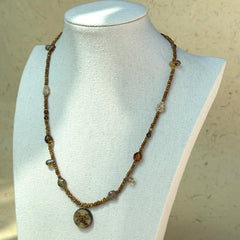 Rustic brown seed bead strand with zodiac-inspired design