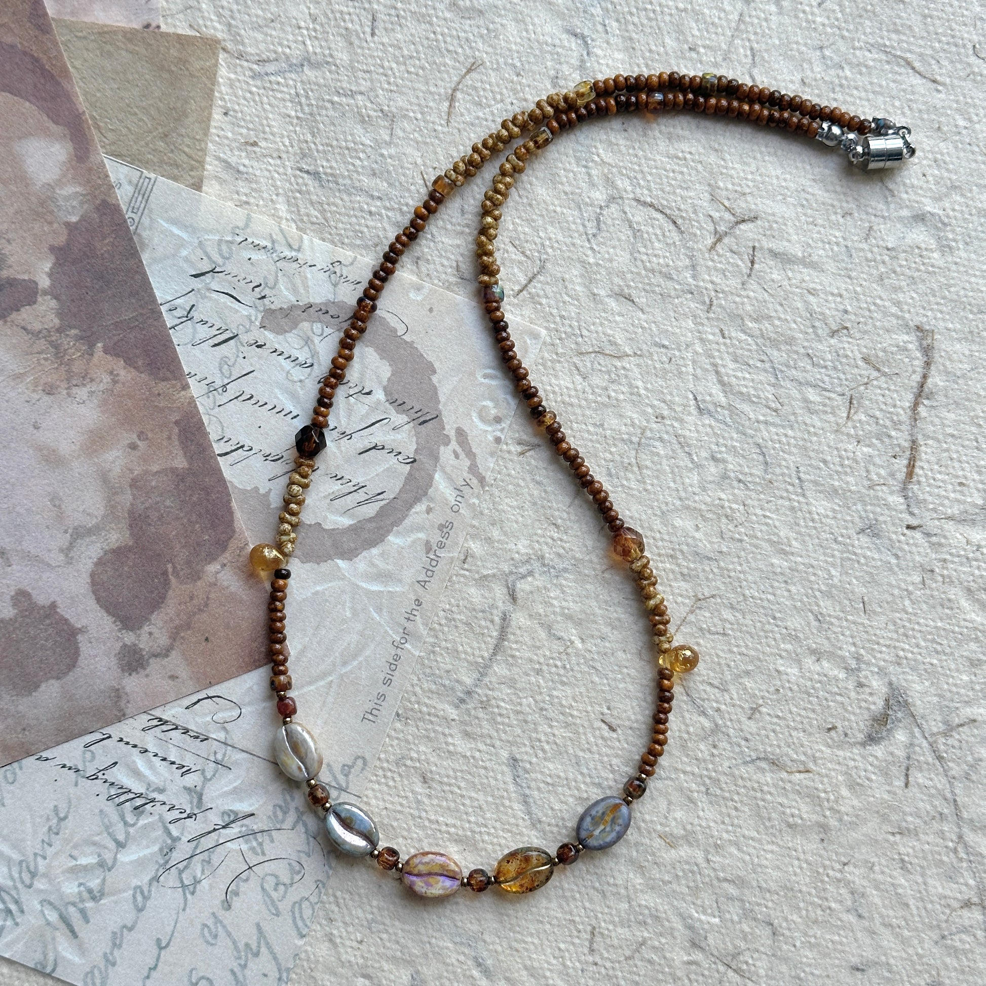 Sunset Relic Necklace with amber and smoky beads on display bust
