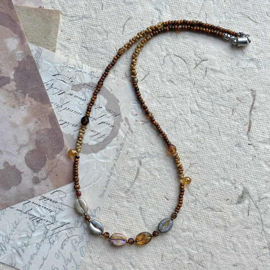 Sunset Relic Necklace with amber and smoky beads on display bust