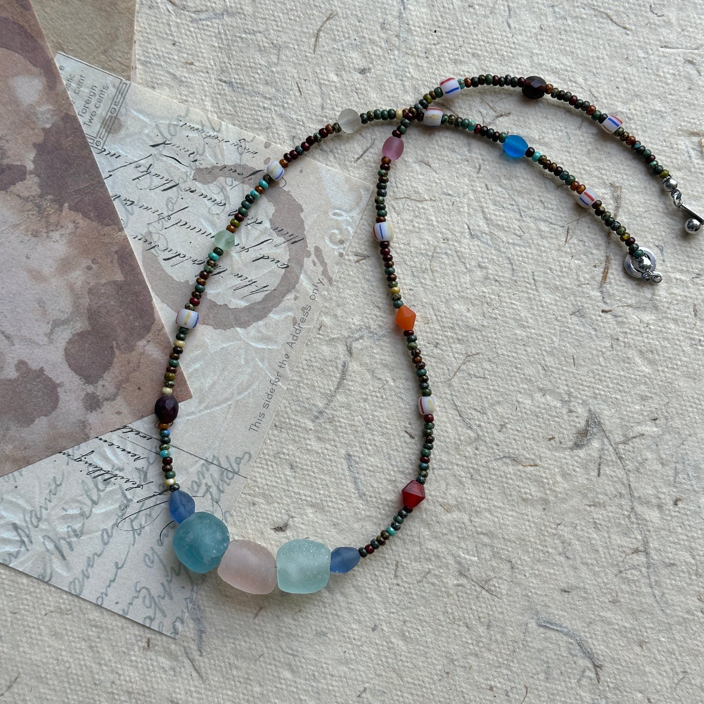 Wanderlust Stone Necklace with multicolor beads on textured background