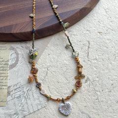 Heart of Leaves Necklace with heart-shaped leaf pendant on textured background