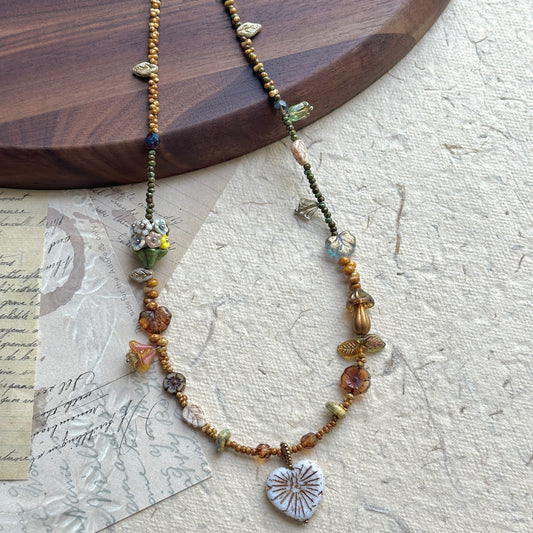 Heart of Leaves Necklace with heart-shaped leaf pendant on textured background