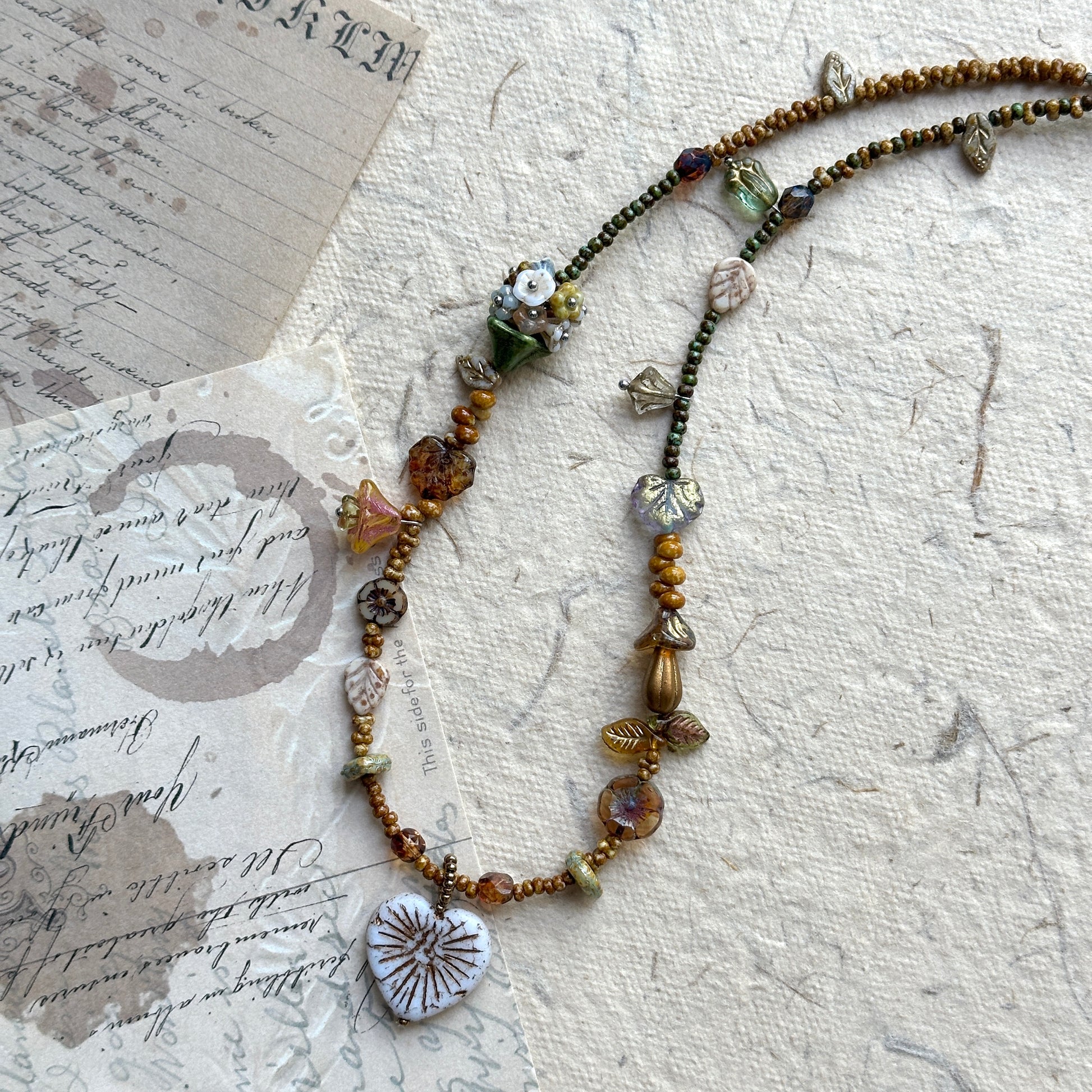 Rustic handcrafted necklace in earthy green, gold, and amber hues
