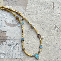Close-up of turquoise leaf focal bead with rustic golden strand