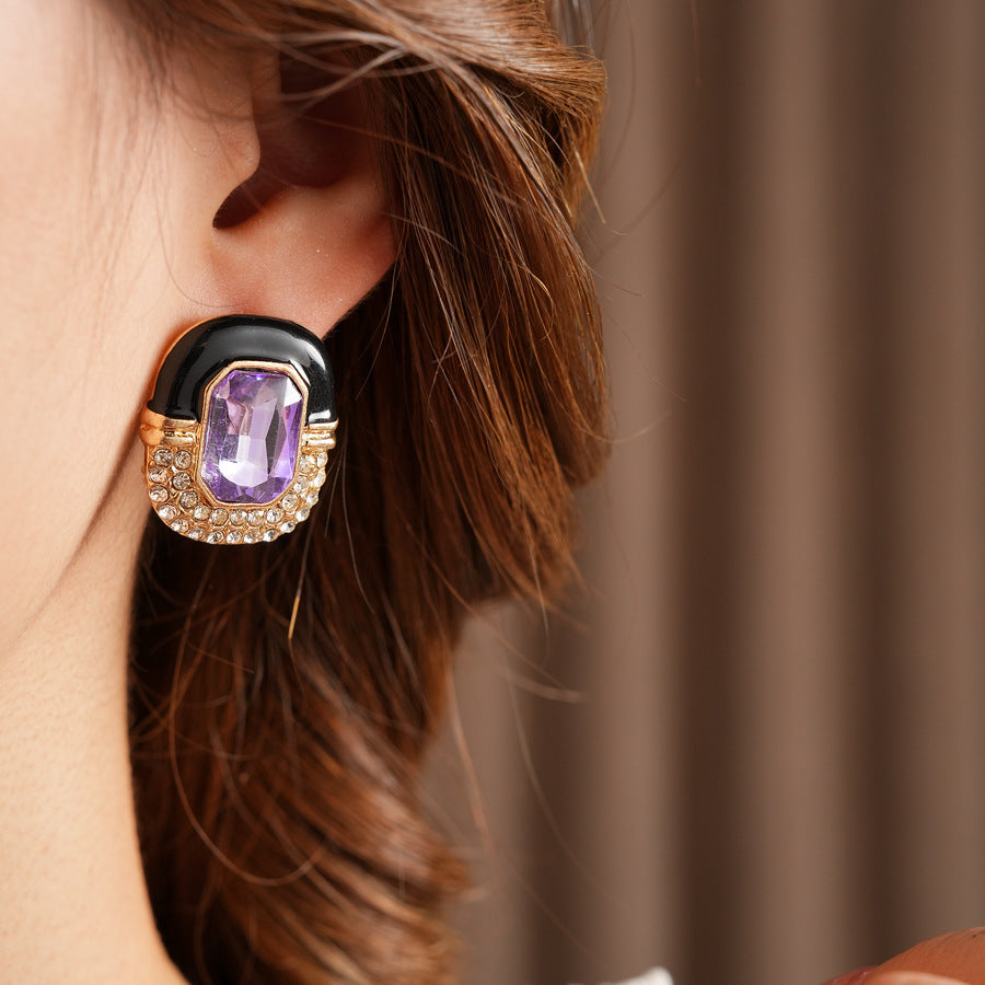 Black enamel stud earrings with amethyst-tone crystal and rhinestone frame — Midnight Amethyst Radiance Earrings.
