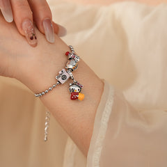 Kawaii Charm Story Bracelet with cartoon cat, burger, camera, and bell charms on silver-tone bead chain