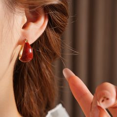 Cherry-red enamel dome huggie hoop earrings with gold tone finish — Cherry Lacquer Dome Huggies.