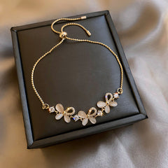 Gold-plated bracelet collection with pearls, cat’s eye stones, and floral motifs