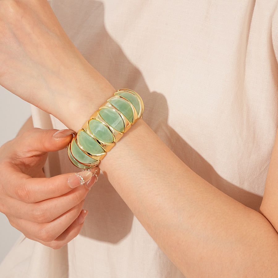 Gold-tone segmented bangle with marbled acrylic dome tiles — Gilded Capsule Resin Bangle.