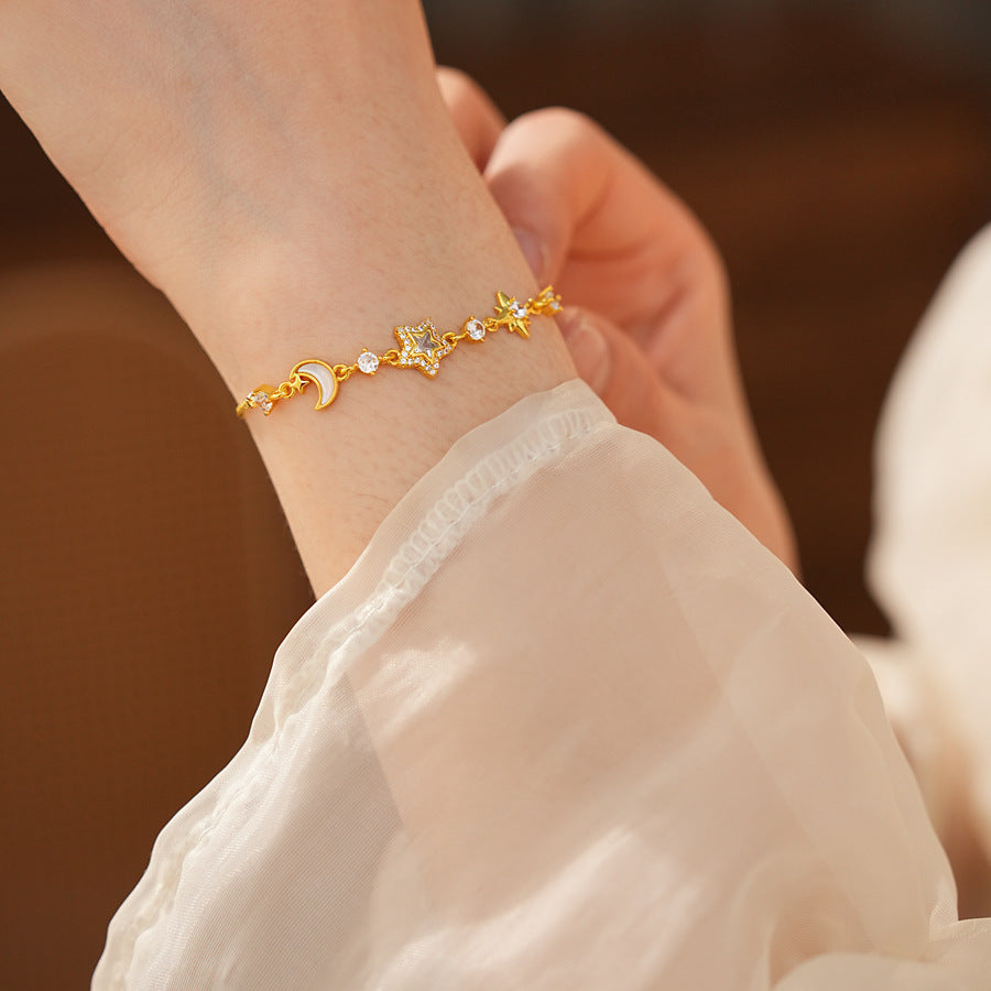 Lunar Starlight Charm Bracelet with crescent moon and star motifs on gold-tone chain – Glazenya
