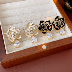 Gold-tone rose stud earrings with ivory and black enamel petals plus teardrop zircon dangles — Gilded Rose Teardrop Studs.