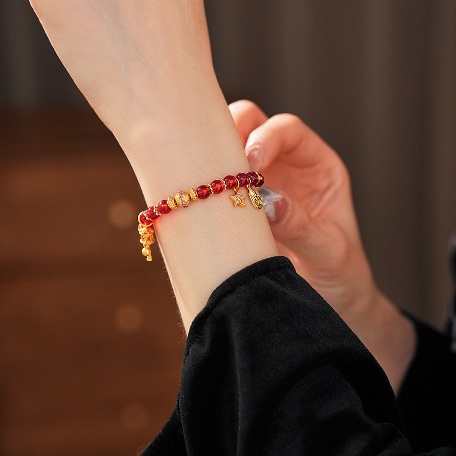 Aurora Red Prosperity Bracelet with red crystal beads and golden fortune charms—star, coin, and drum—on adjustable chain – Glazenya