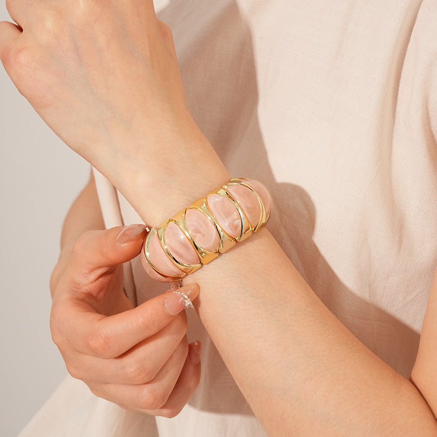Gold-tone segmented bangle with marbled acrylic dome tiles — Gilded Capsule Resin Bangle.