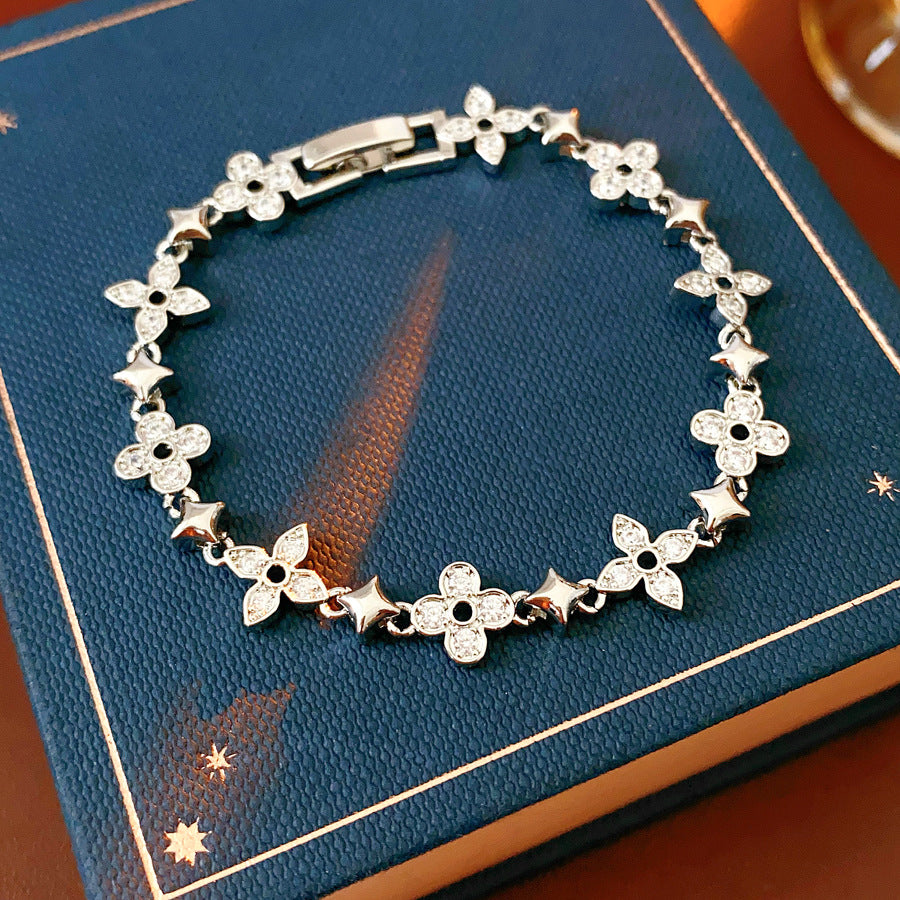 Radiant Flora Bracelet with zircon-studded floral and star motifs on dark blue box – Glazenya jewelry