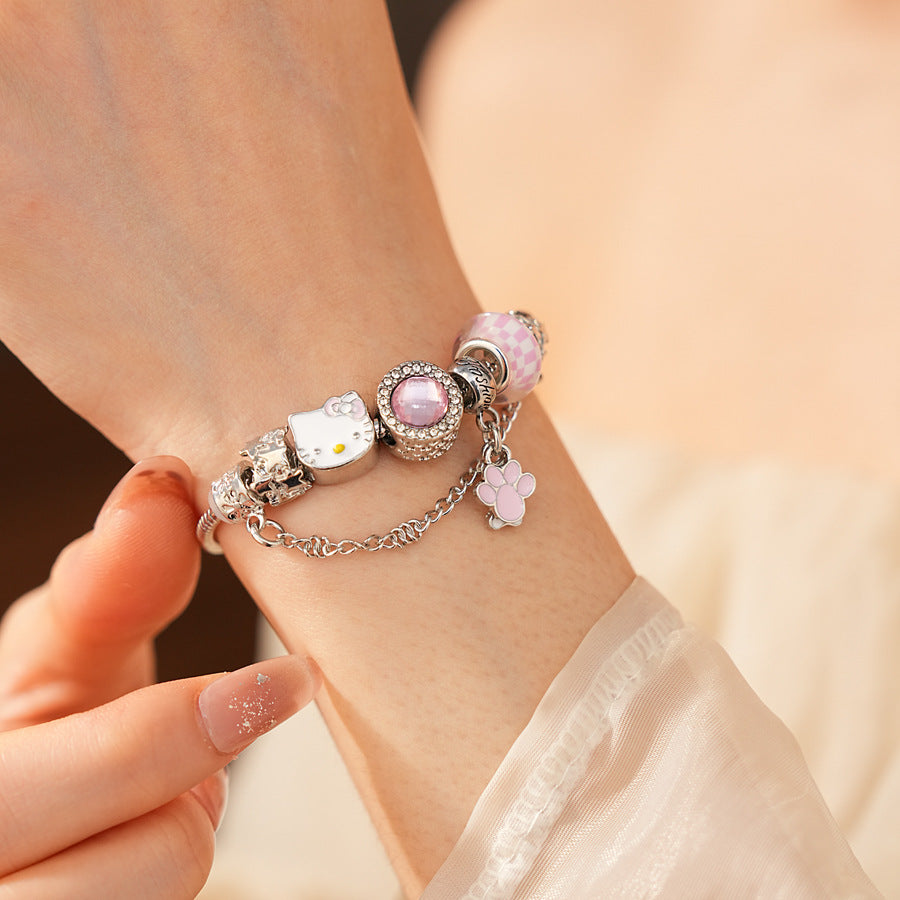 Rosy Pawprints Charm Bracelet — silver-tone snake chain with pink crystal bezel, checker enamel bead, cat-with-bow, paw and bone charms in jewelry tray