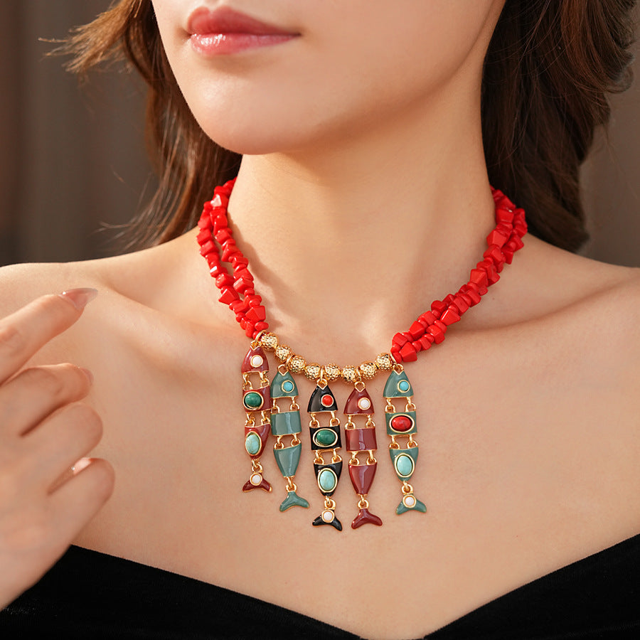 Statement necklace with articulated fishbone fringe, gold beads, and red or black chip strands — Kaleido Fishbone Fringe Necklace.