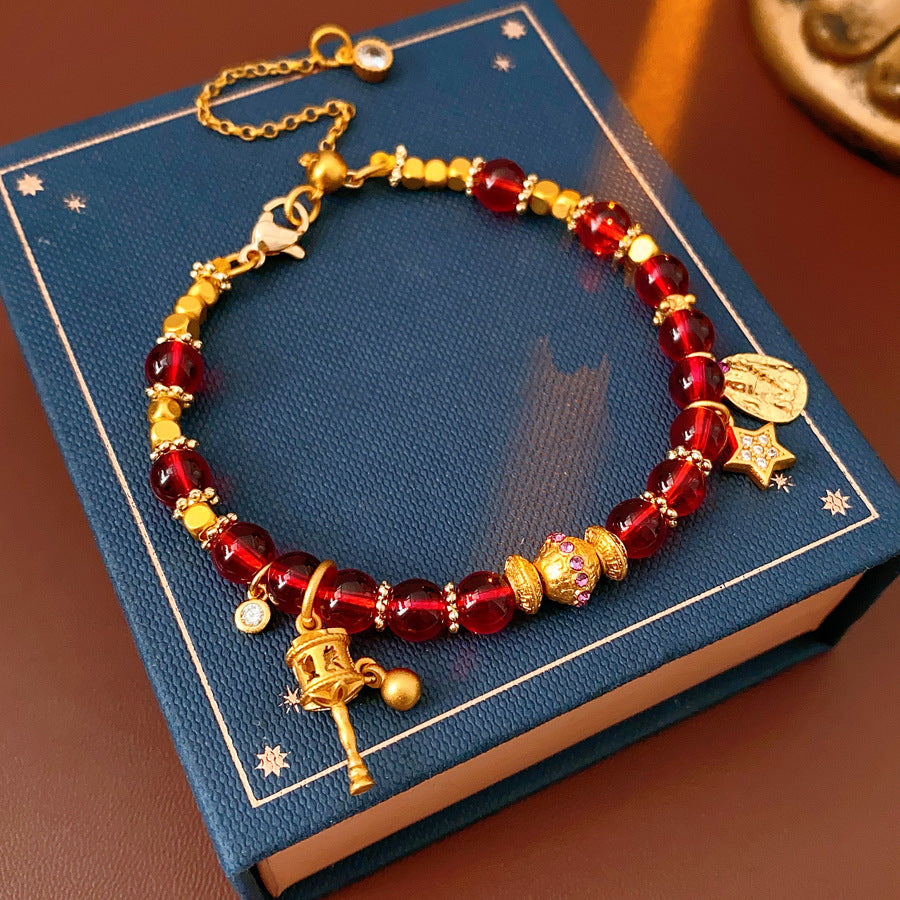 Aurora Red Prosperity Bracelet with red crystal beads and golden fortune charms—star, coin, and drum—on adjustable chain – Glazenya
