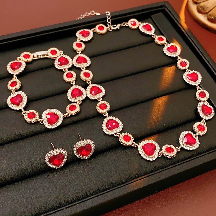 Crimson Heart Luxe Collection with red heart gemstone necklace, bracelet, and earrings, accented with pavé details