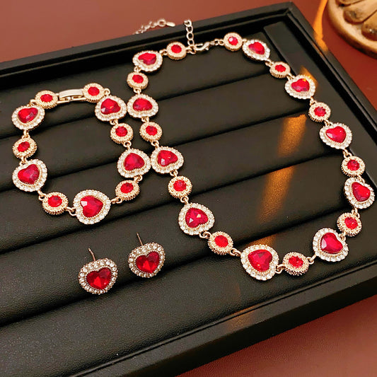 Crimson Heart Luxe Collection with red heart gemstone necklace, bracelet, and earrings, accented with pavé details