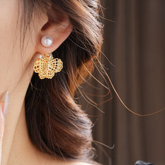 Double-pearl stud earrings with gold-tone butterfly and star charms displayed in a jewelry tray — Double Pearl Charm Studs.