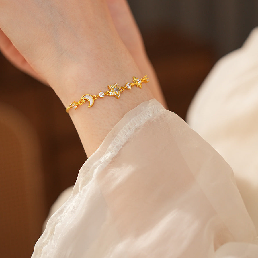 Lunar Starlight Charm Bracelet with crescent moon and star motifs on gold-tone chain – Glazenya