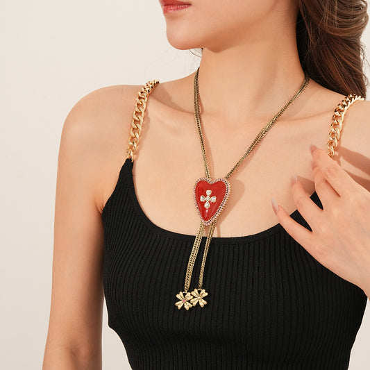 Lariat necklace with beaded-edge heart pendant and twin tassel blossoms on model — Regal Heart Tassel Lariat Necklace.