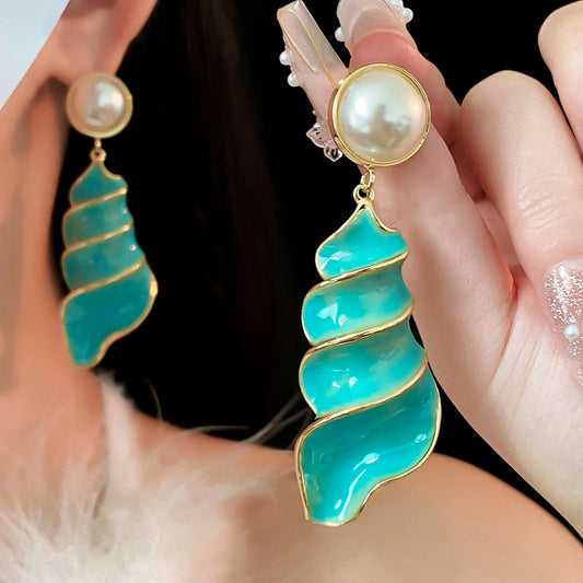 Lagoon Spiral Pearl Drop Earrings — glossy turquoise spiral shell drops with pearl studs and gold trim on jewelry tray