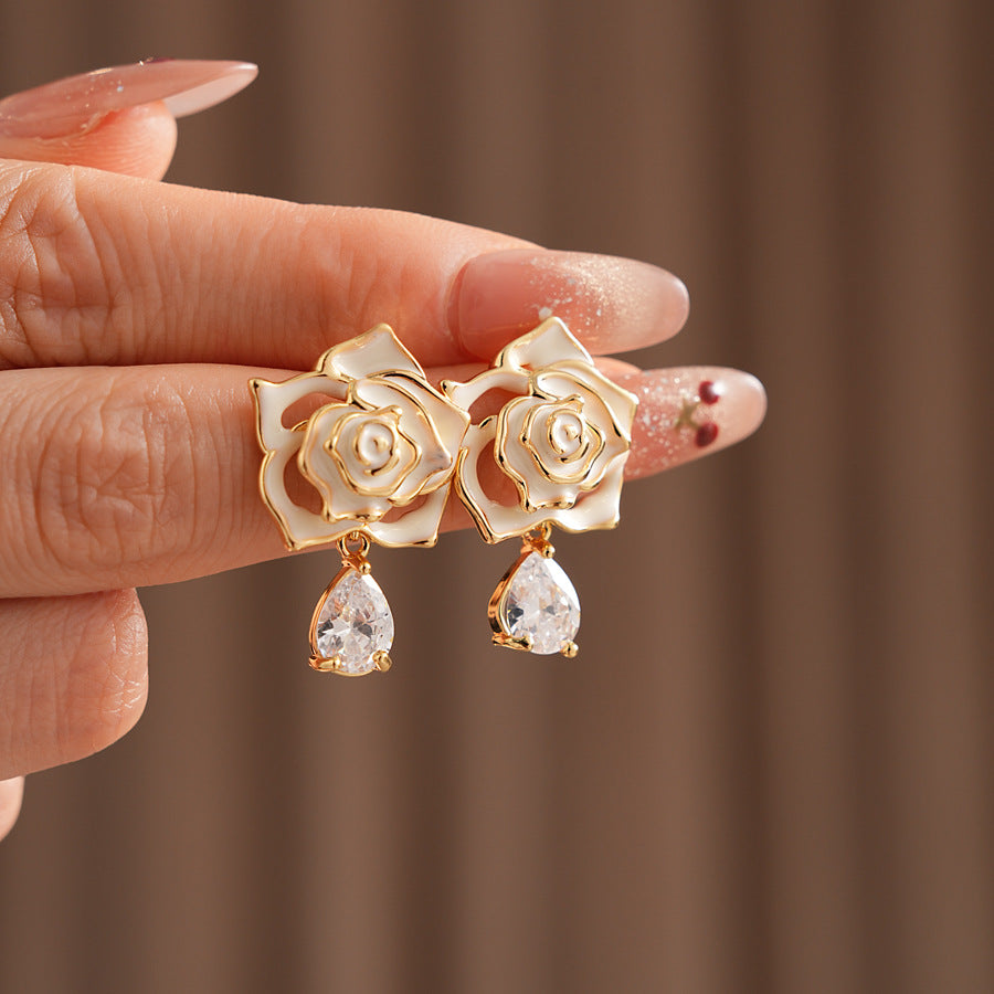 Gold-tone rose stud earrings with ivory and black enamel petals plus teardrop zircon dangles — Gilded Rose Teardrop Studs.