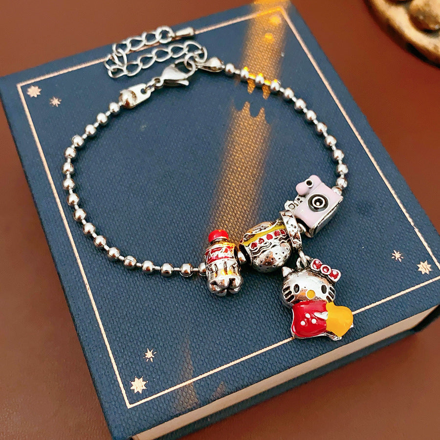 Kawaii Charm Story Bracelet with cartoon cat, burger, camera, and bell charms on silver-tone bead chain