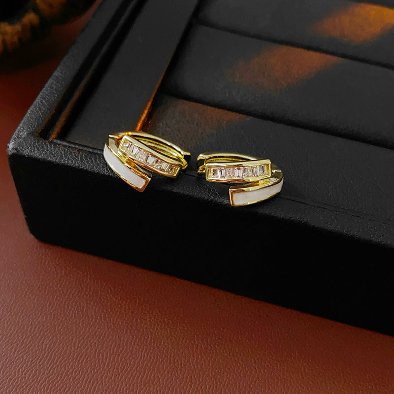Gold huggie hoop earrings with ivory enamel arc and baguette CZ row — Luna Arc Enamel Baguette Huggies.