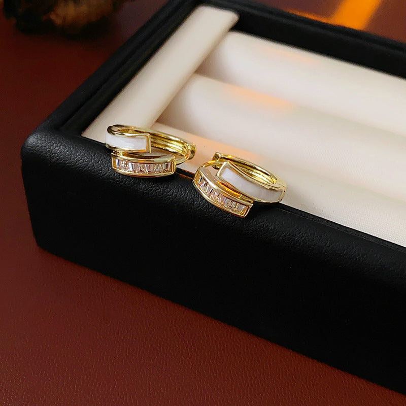 Gold huggie hoop earrings with ivory enamel arc and baguette CZ row — Luna Arc Enamel Baguette Huggies.