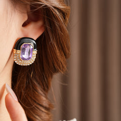 Black enamel stud earrings with amethyst-tone crystal and rhinestone frame — Midnight Amethyst Radiance Earrings.